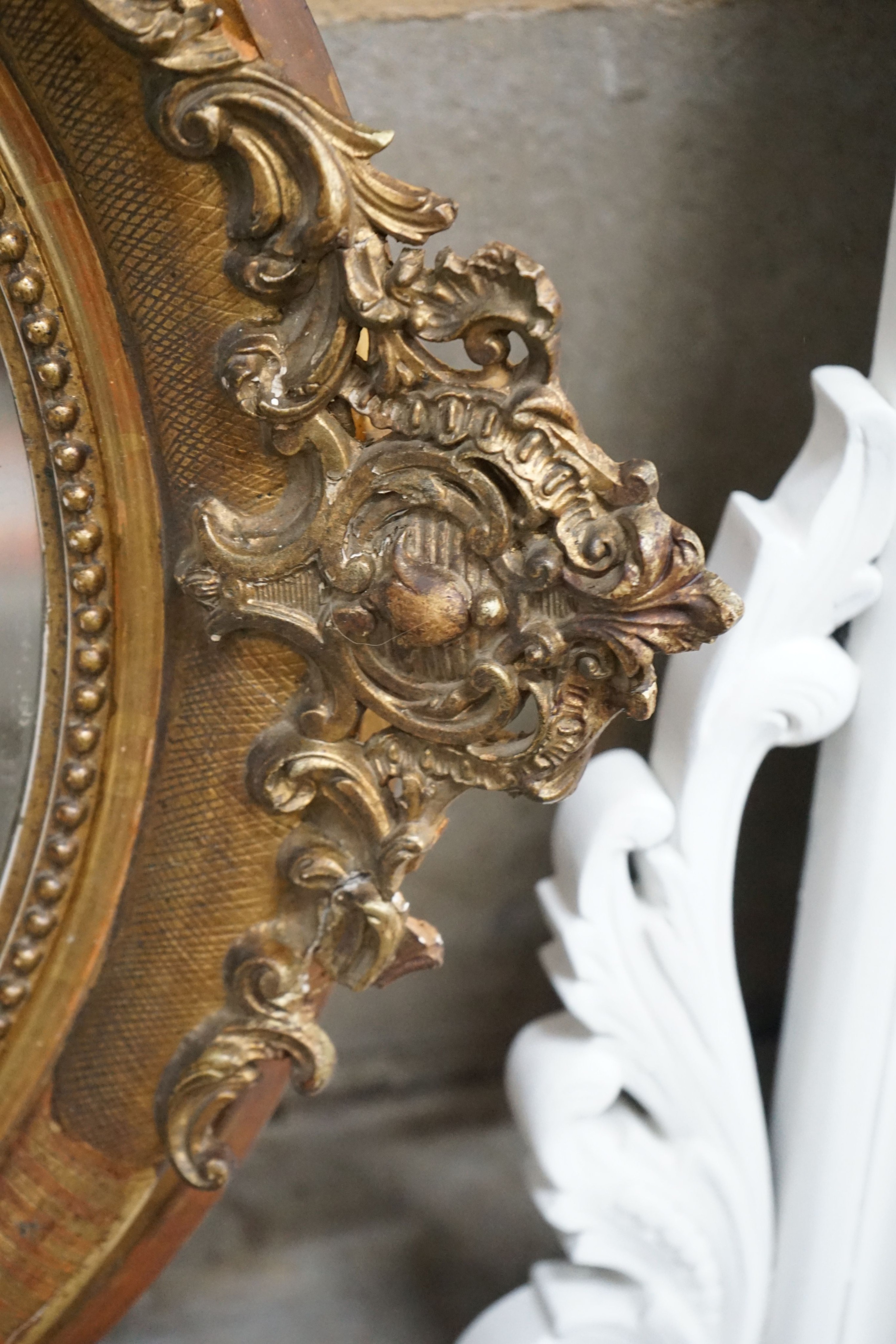 A 19th century French oval giltwood and gesso wall mirror with pierced 'C' scroll and shell pediment, width 78cm, height 118cm
